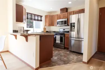 Kitchen with SS appliances, gas stove, walkway to the 2 car garage