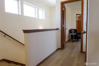 Stairs and corridor. Up front - the primary bedroom, door on the right - gas furnice