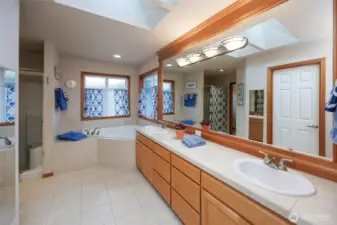 Primary bathroom w/tiled floors/countertops. Dual vanities/corner soaking tub /walk in shower and large walk in closet.