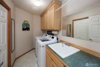 upper level Utility room w/large closet/utility sink and upper storage cabinets.