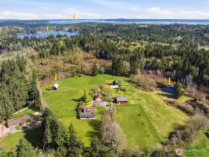 Aerial view of Bay Lake, Carr Inlet, home, homestead barn, mini-barn, loafing shed, pastures, shop, detached garage and the duck pond.