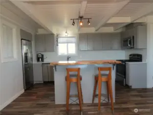 VIEW TOWARDS THE KITCHEN WITH THE QUARTZ COUNTER TOPS AND ISLAND EATING BAR!