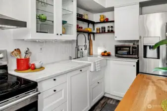 Updated kitchen with fresh cabinets and stainless-steel appliances. The dishwasher has a cabinet front (next to the sink) and the corner cabinet has shelves that pull out for extra storage.