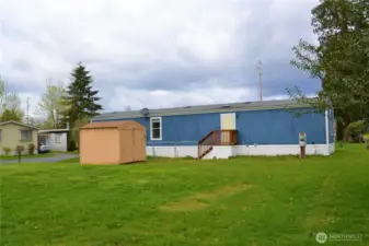 Both sides of the home have huge community maintained lawns.  The chain link fence by the porch is not included, but shows the space that the home owner uses.  The shed on this side belongs to the management company.