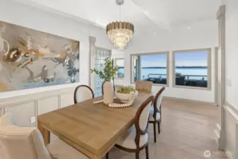 An elegant dining room offers southwest-facing, expansive views—the perfect setting for gatherings, celebrations, and savoring every moment of lakeside enjoyment.