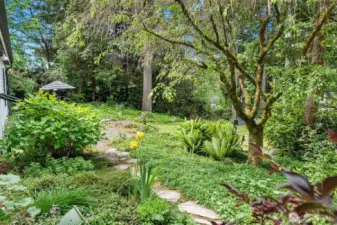 A pathway leads through the gardens to the front door.