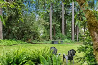A gentle sloped lawn boarders the lake, greenbelt, and garden area.