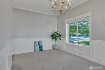 The formal dining room features custom molding and a chandelier-along with a large window for ambient light during the day.