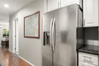 Hallway from side door/second bedroom toward main bath and kitchen.  Large second refrigerator/freezer and extra storage here.