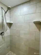 Walk-in tiled shower in the primary.