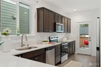 Quartz counters, rich wood cabinetry, SS appls