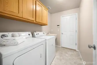 The laundry room with utility sink connects the main living level to the 3-car garage.