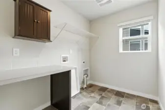 Upper level Laundry Room with counter space and storage.