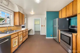 The kitchen has bountiful storage space and updated stainless appliances. Laundry room shown straight ahead.