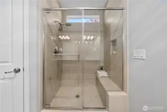 Fully tiled shower with a convenient bench and handy niche.