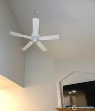 vaulted living room with ceiling fans