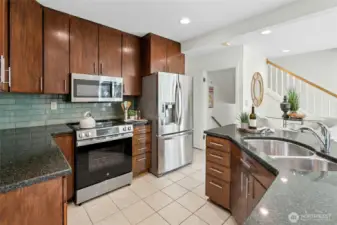 Chefs delight in this spacious modern kitchen with granite countertops, glass tile backspace, stainless steel appliances, and tons of storage space.