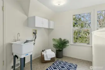 Conveniently located laundry area with utility sink in upper level loft space.