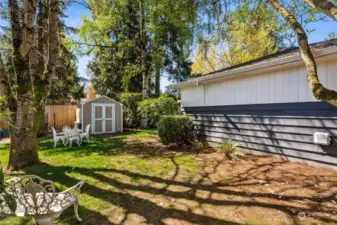 The spacious side yard includes a storage shed.