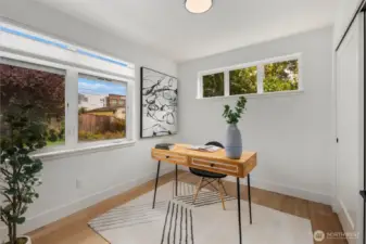 Bright main floor bedroom with dual exposures, offering a peaceful view of greenery and plenty of natural light.