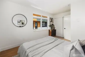 Filled with natural light from windows on two sides, this main floor bedroom offers a versatile layout and modern style for rest, work, or hobbies.