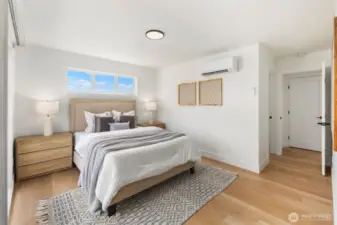 The primary suite features warm hardwood floors, clerestory windows that invite daylight, and a modern mini-split for personalized comfort.
