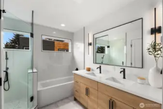 Sunlit and serene, this modern primary bath features a frameless glass shower, a relaxing soaking tub, and a wall of windows that fill the space with natural light.