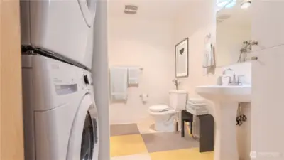 Functional bathroom with generous storage cabinet and added convenience of a new washer and dryer.