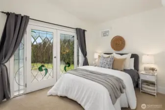 Home #2: Bedroom with custom stained glass french doors and sidelight windows. This bedroom also has a walk-in closet.