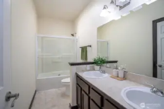 Main guest bathroom includes dual sinks, offering added convenience and functionality.