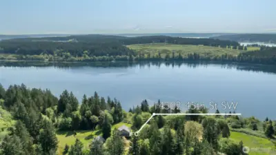 Drone looking east over passage and McNeil Island with Cascades in the background.