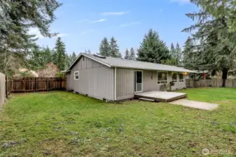 Fully-fenced backyard with covered patio off the kitchen and deck off the primary bedroom.