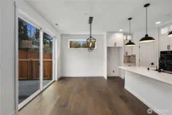 Dining Area:  This airy dining space is framed by wide-plank flooring and anchored by a sculptural modern chandelier that adds definition without overwhelming the openness. The room’s proximity to the kitchen and backyard supports easy transitions between weeknight meals, gathering, and indoor–outdoor entertaining. Situated in Bothell’s Canyon Park micro-area, the home offers quick access to nearby parks, trails, and everyday amenities while remaining close to major commuter connections. The clean lines and natural light make this dining area versatile enough for both casual living and more elevated occasions.    These photos are from Lot 5 at Gooden Hollow, the home listed here. However, other homes in the community will have changes, so all photos, renderings, site maps, and floorplans are for visualization purposes only. Plans, colors, building orientation, finishes, home outlook, and other details can and WILL vary.