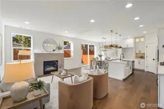 Great Room:  Large windows spill natural light across the great room, highlighting the wide-plank flooring and the gas fireplace wrapped in soft neutral tile. The open flow invites flexible furniture placement and comfortable day-to-day living. With Gooden Hollow’s Bothell location near Canyon Park amenities, this room becomes a peaceful backdrop to Northwest living, surrounded by mature evergreens and convenient access to nearby recreation. Its simplicity and warmth make it equally suited for quiet evenings or effortless entertaining.    These photos are from Lot 5 at Gooden Hollow, the home listed here. However, other homes in the community will have changes, so all photos, renderings, site maps, and floorplans are for visualization purposes only. Plans, colors, building orientation, finishes, home outlook, and other details can and WILL vary.