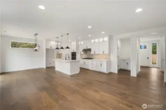 Main Living Overview:  Wide sightlines connect the kitchen, dining area, and great room, emphasizing natural light from multiple windows and the warm tones of the engineered hardwoods. This open-concept layout offers exceptional flexibility for furniture placement and comfortable living. Located in Bothell’s Canyon Park area, the home provides quick access to shopping, Northshore schools, and major commuting routes, making day-to-day life both convenient and connected. The scale of the space lends itself beautifully to hosting, creating room for gatherings of all types while maintaining a clean, modern aesthetic.    These photos are from Lot 5 at Gooden Hollow, the home listed here. However, other homes in the community will have changes, so all photos, renderings, site maps, and floorplans are for visualization purposes only. Plans, colors, building orientation, finishes, home outlook, and other details can and WILL vary.