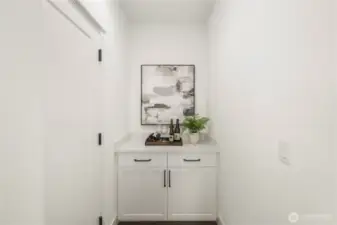 Garage Entry “Drop Zone” Area:  Just inside the garage entry, this versatile drop zone provides a practical transition space designed for organization and everyday convenience. Built-in cabinetry and counter space make it ideal for device charging, organizing bags and gear, or even creating a compact coffee station or bar setup. Located in Bothell’s Canyon Park neighborhood, the home supports active lifestyles with nearby parks, trails, and commuter routes that keep daily routines moving smoothly. The clean finishes and smart layout transform this functional area into an elevated extension of the main living spaces.    These photos are from Lot 5 at Gooden Hollow, the home listed here. However, other homes in the community will have changes, so all photos, renderings, site maps, and floorplans are for visualization purposes only. Plans, colors, building orientation, finishes, home outlook, and other details can and WILL vary.