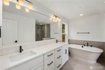 Primary Bath:  The primary bath showcases a long dual-sink vanity with quartz counters, modern lighting, and warm tile floors that contribute to a spa-like atmosphere. A soaking tub sits beside a large window, inviting natural light while maintaining privacy. Situated within Bothell’s Canyon Park area, this serene bath offers a relaxing retreat close to everyday conveniences, trails, and community amenities. With abundant counter space, matte black fixtures, and thoughtful design details, the space feels both luxurious and highly functional.    These photos are from Lot 5 at Gooden Hollow, the home listed here. However, other homes in the community will have changes, so all photos, renderings, site maps, and floorplans are for visualization purposes only. Plans, colors, building orientation, finishes, home outlook, and other details can and WILL vary.