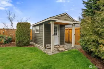 Custom storage shed complementing the landscaped grounds.