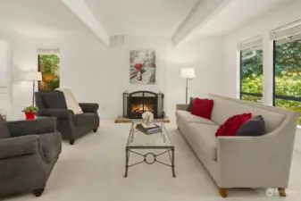 The living room features beamed ceilings, and a full-height brick wood-burning fireplace