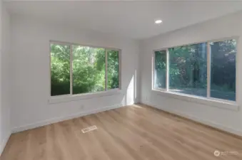 Another view of bed 2 off entry way with large windows looking out to nature