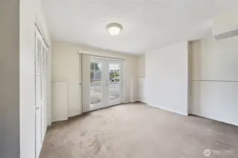Additional bedroom on the lower level with French Door access from the driveway. Washer and Dryer are in the closet to the left. (virtual staging removed items stored in this room)