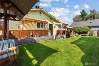 Backyard set up with covered BBQ area and swing.