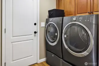 The laundry room includes upper cabinetry.