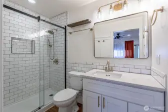 Great use of the tile & space. Oversized vanity & landscape mirror look great.  Tiled shower up to the ceiling with built in niche.