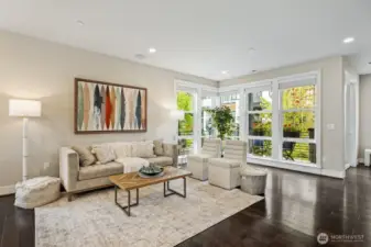 Open, light-filled living space with soaring ceilings and expansive floor to ceiling windows