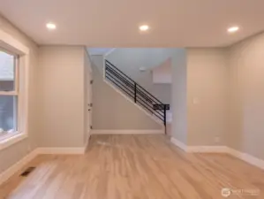 Front entry and living area with new solid plank vinyl floors and custon railing on stairway.