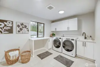 Large second floor laundry room with sink and tons of storage space