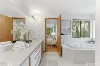 The primary bath features a long, light-filled vanity with dual sinks and abundant storage underneath.