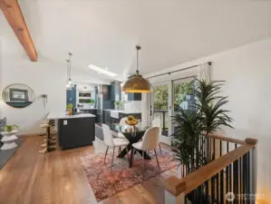 The dining area opens to the expansive open-concept living spaces, featuring a beautiful new light fixture that casts a warm welcoming ambiance.