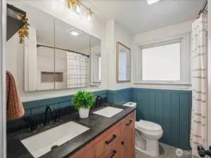 Remodeled full bath in 2022 includes new tile flooring, vanity with dual sinks, tiled tub/shower combo, toilet, lighting and mirror.